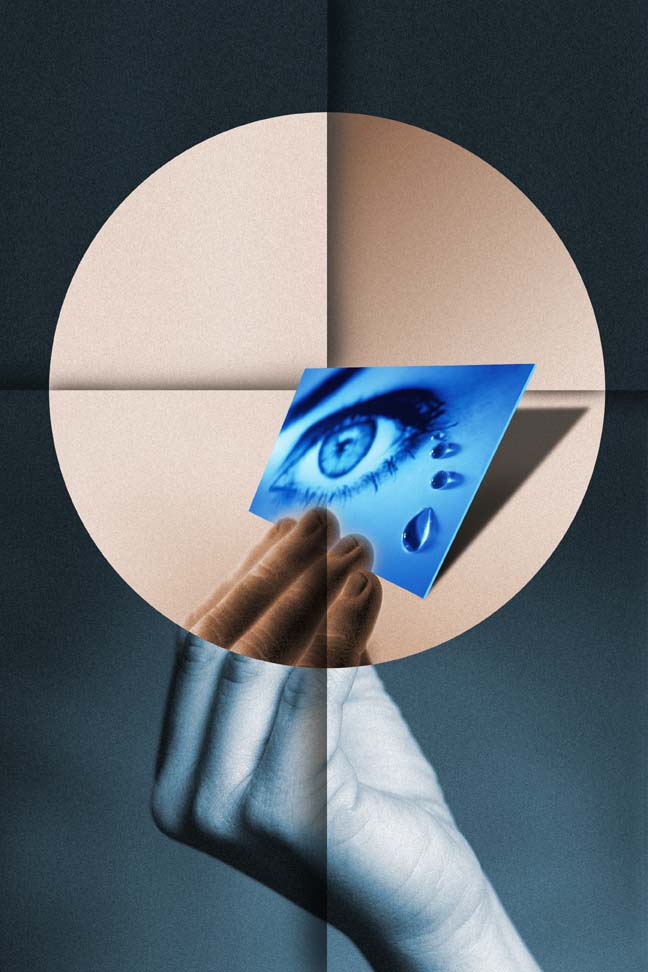 An image of a hand holding a photo of an eye with tears